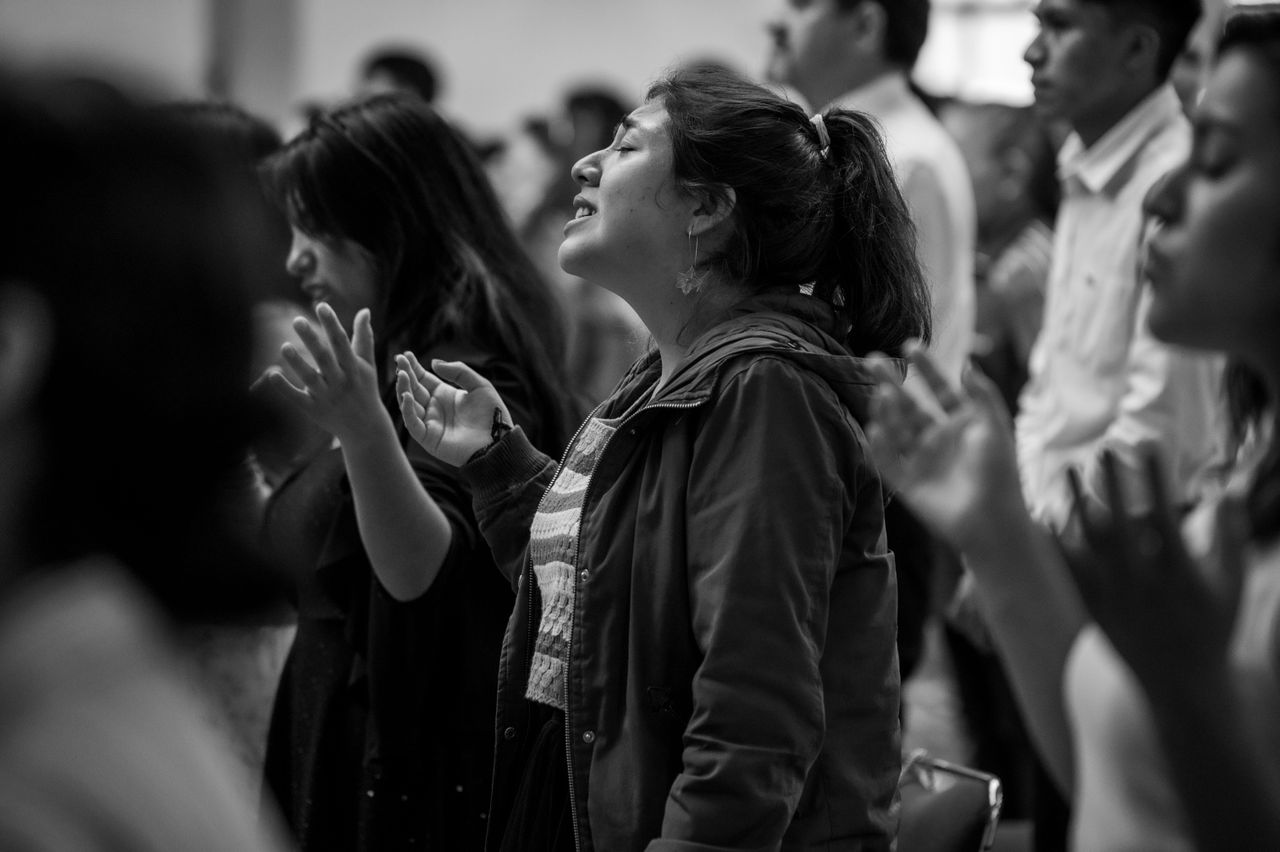 Services Diverse group of people passionately worshiping in a church setting in Mexico City.