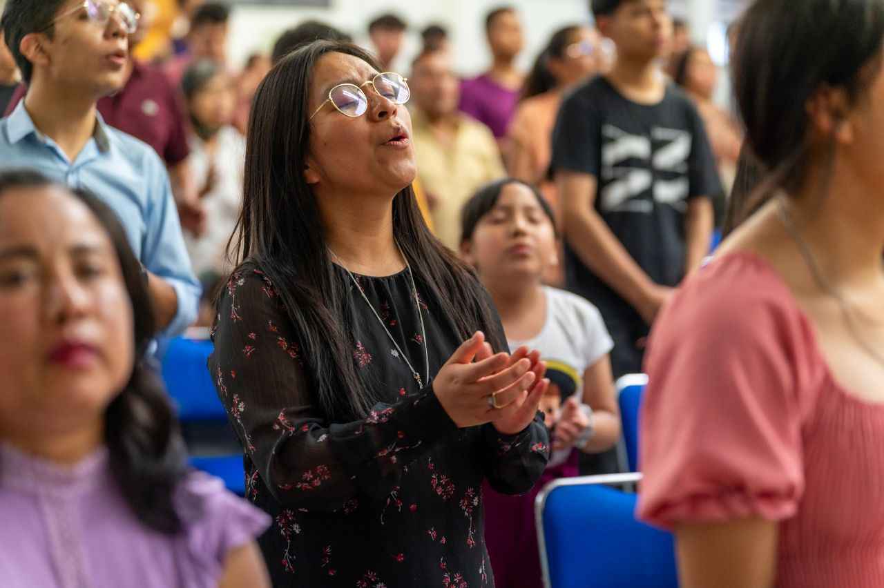 Crafting Captivating Headlines: Your awesome post title goes here A diverse congregation in Ciudad de México engaged in prayer during a church service.